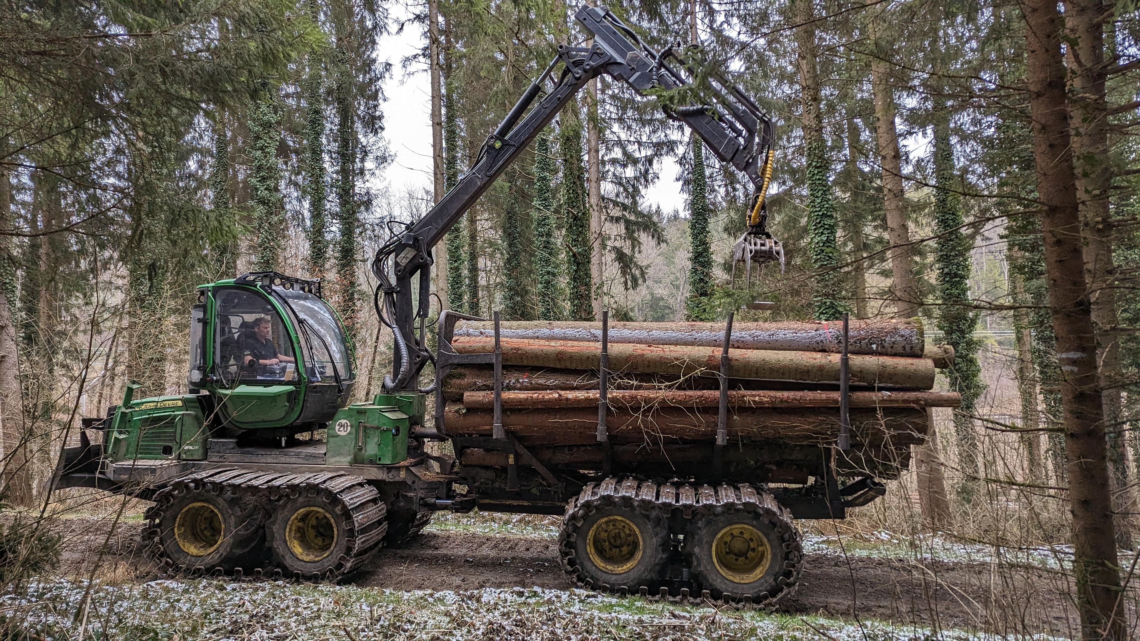 John Deere 810E Rückewagen im Wald im Einsatz